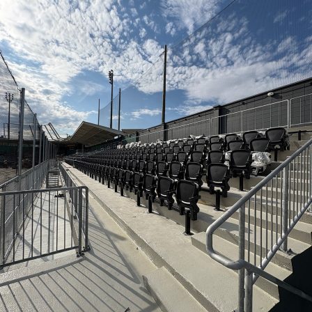 Vue d'ensemble des rangées de sièges noirs du stade Richard-Desmeules.