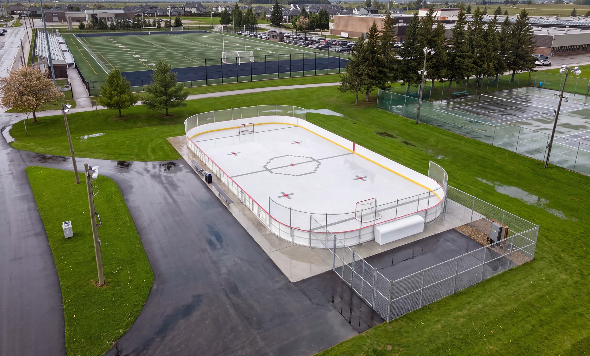 Vue aérienne de la surface multisport NORDIQ dans une patinoire extérieure au printemps.